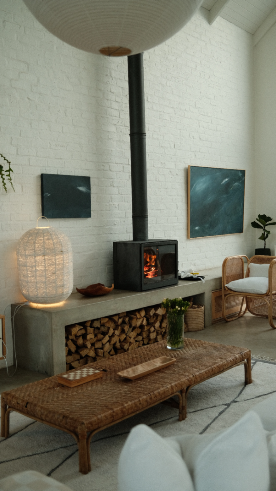 Wood-burner, rattan and quiet artwork composition