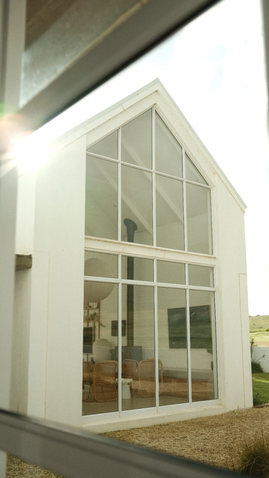 Gabled facade framed through a neighbouring window
